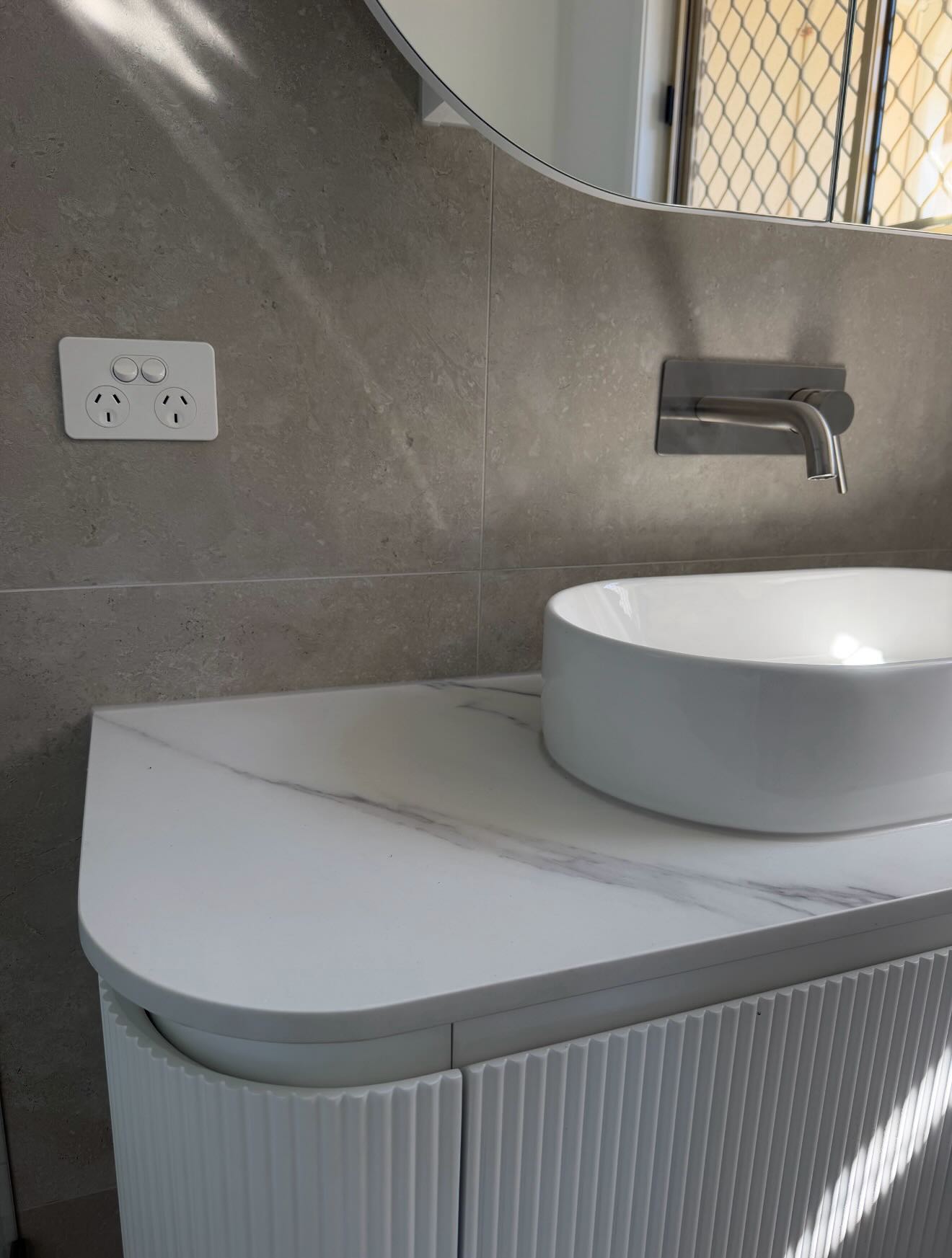 Close-up of a vessel sink and brushed-nickel wall-mounted tap