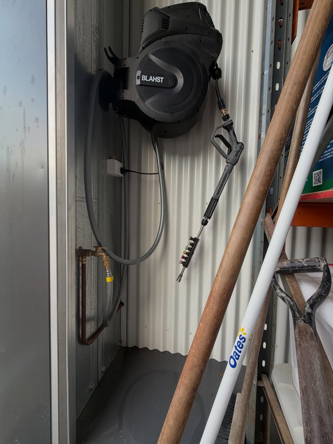 Pressure washer and hose reel mounted inside a shed storage bay